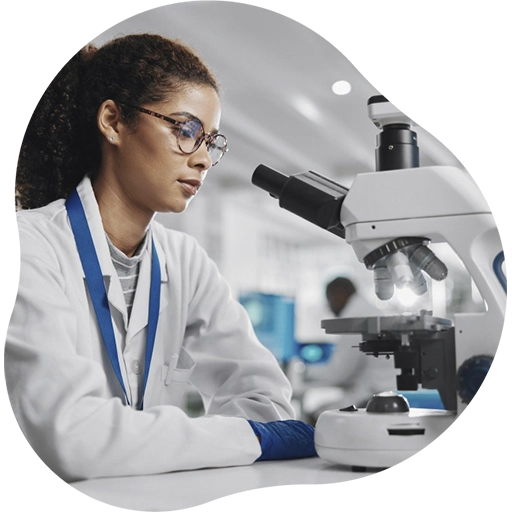 Profissional de laboratório analisando amostra em microscópio em ambiente clínico.